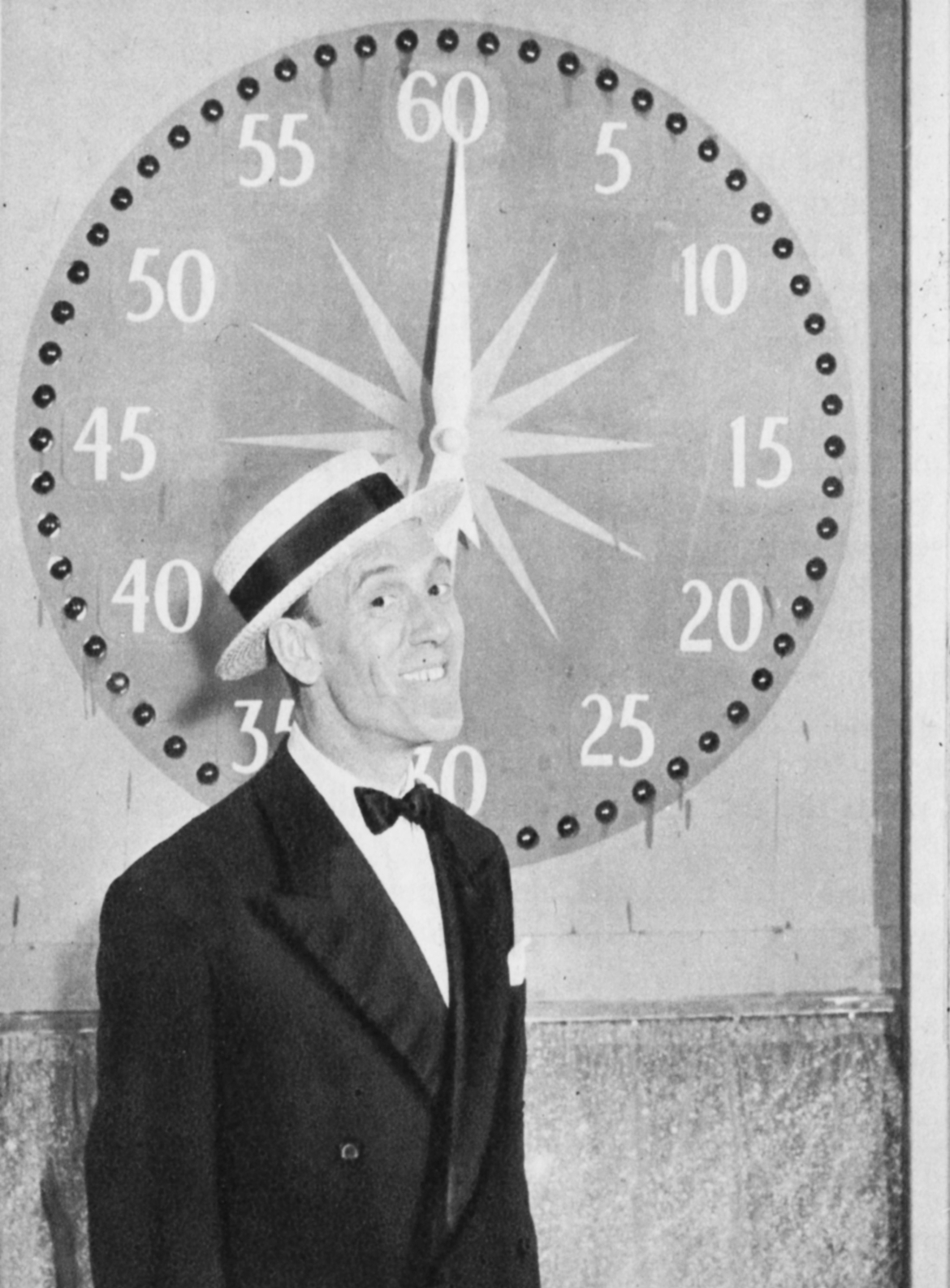 A man stands in front of a decorative clock
