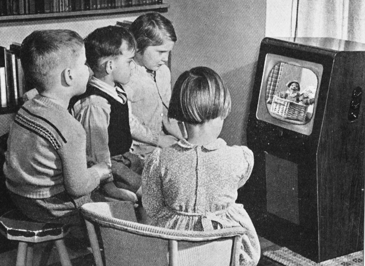 Four children watch Andy Pandy on a TV